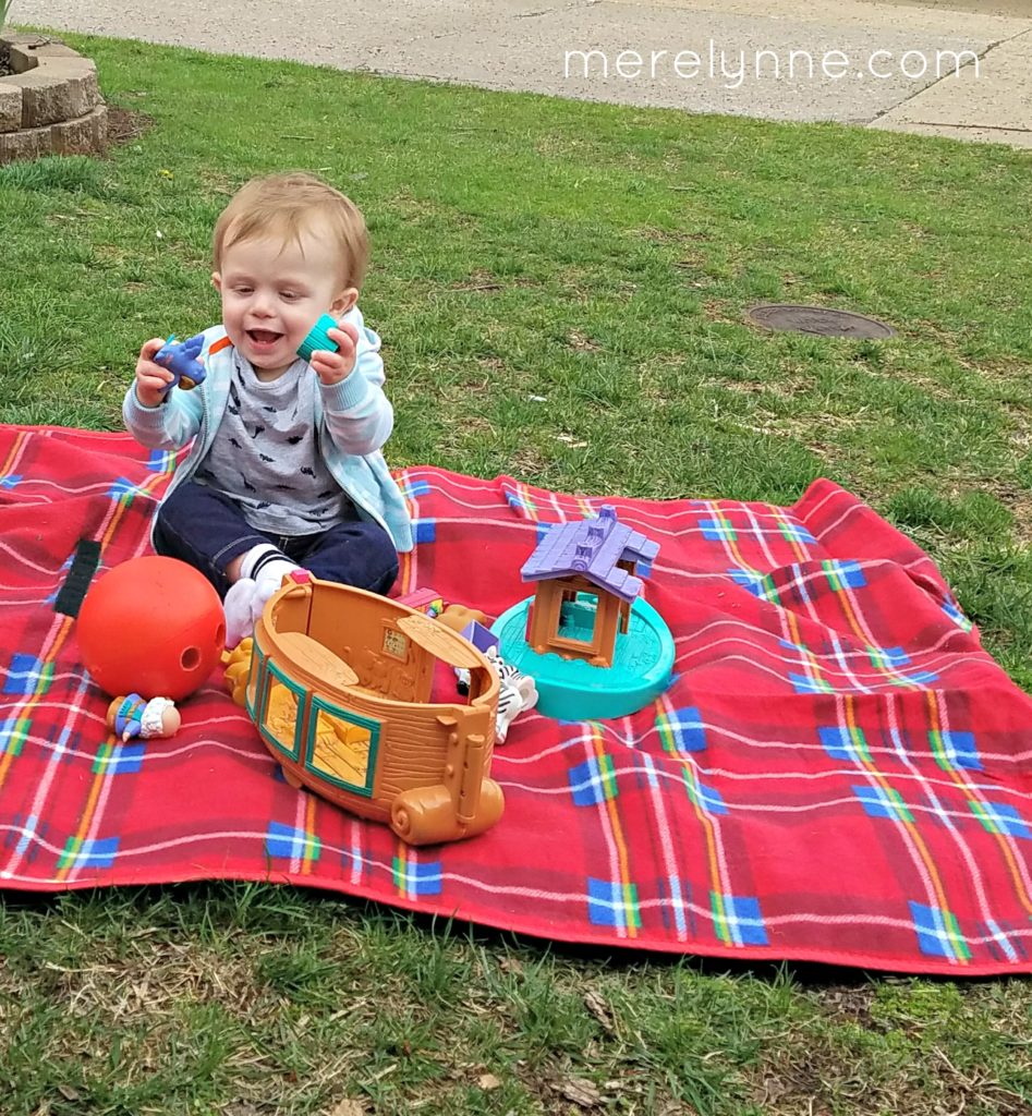 baby playing on picnic blanket, being sick as an adult